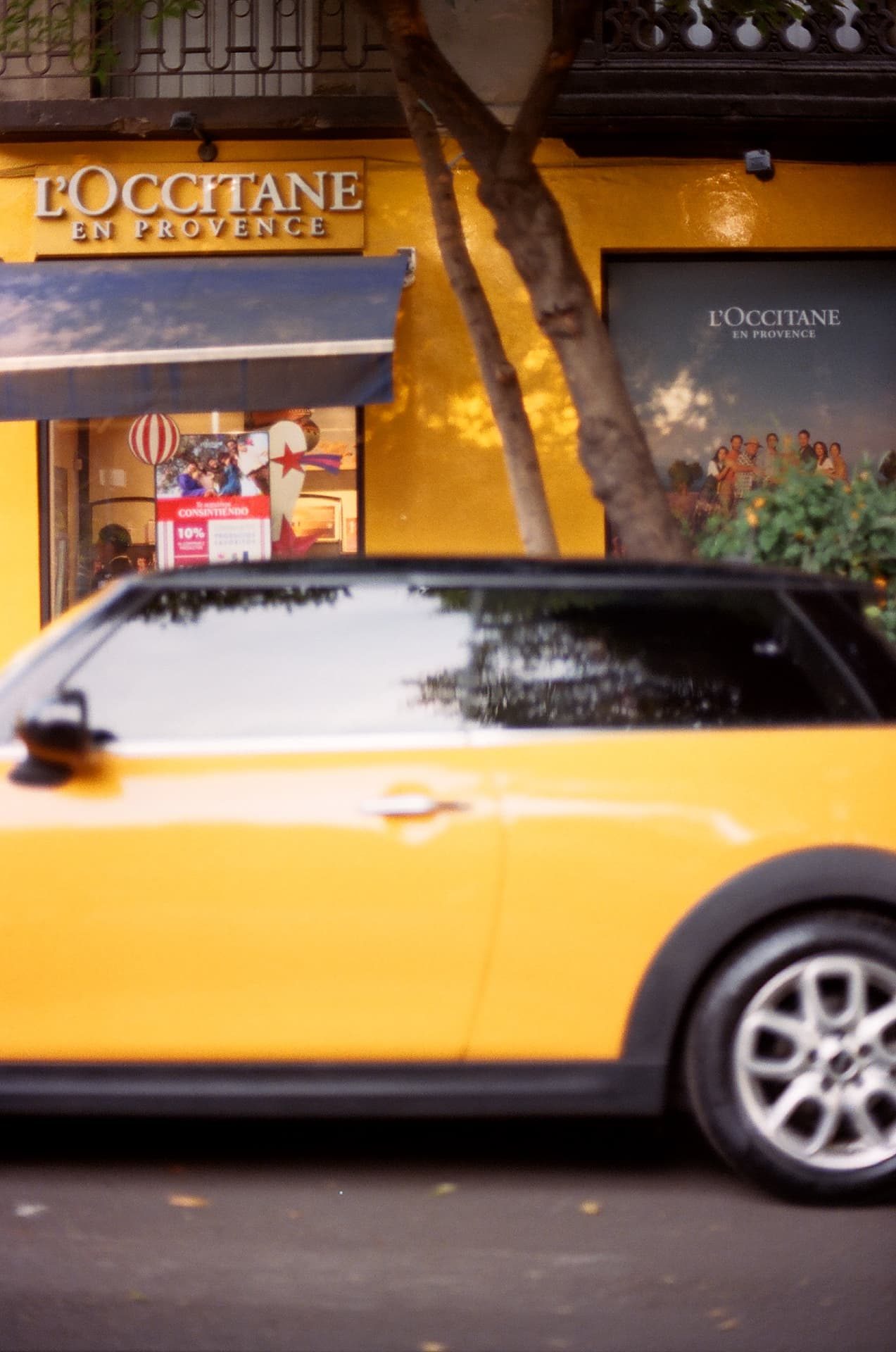 Auto amarillo frente a una tienda con fachada amarilla