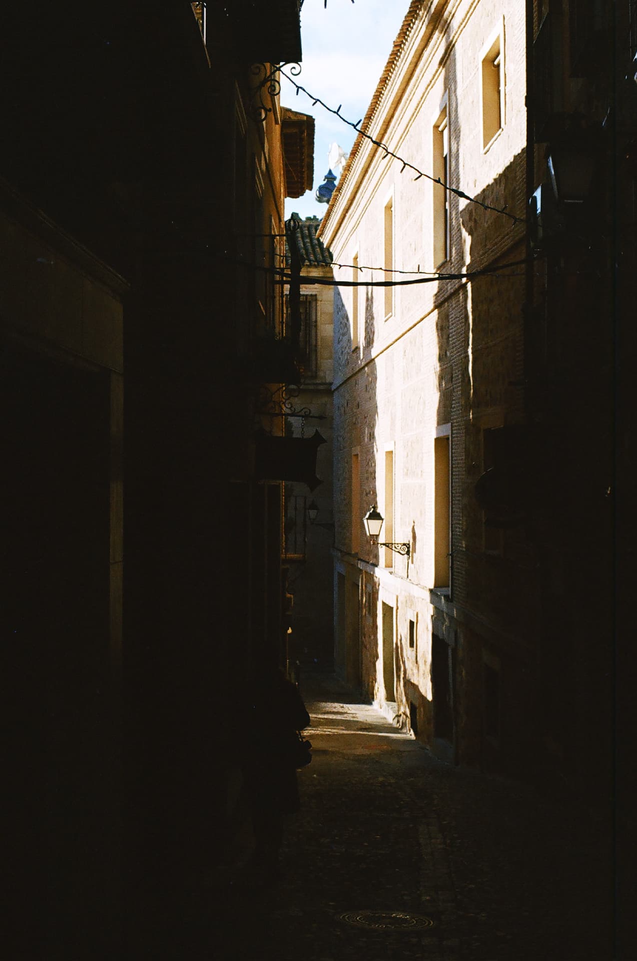 Callejón en sombra atravesado por una franja de luz