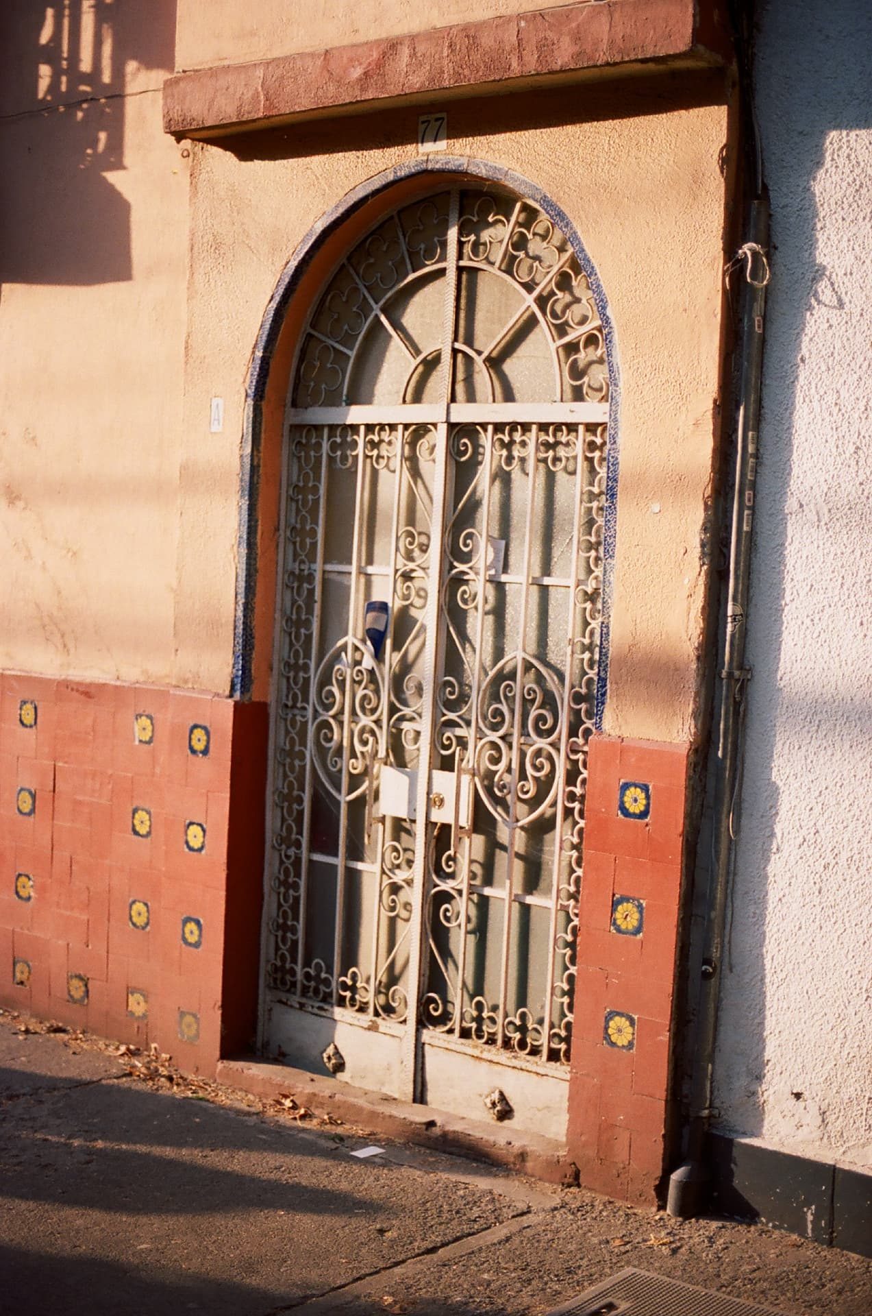 Puerta de herrería con detalles de azulejo