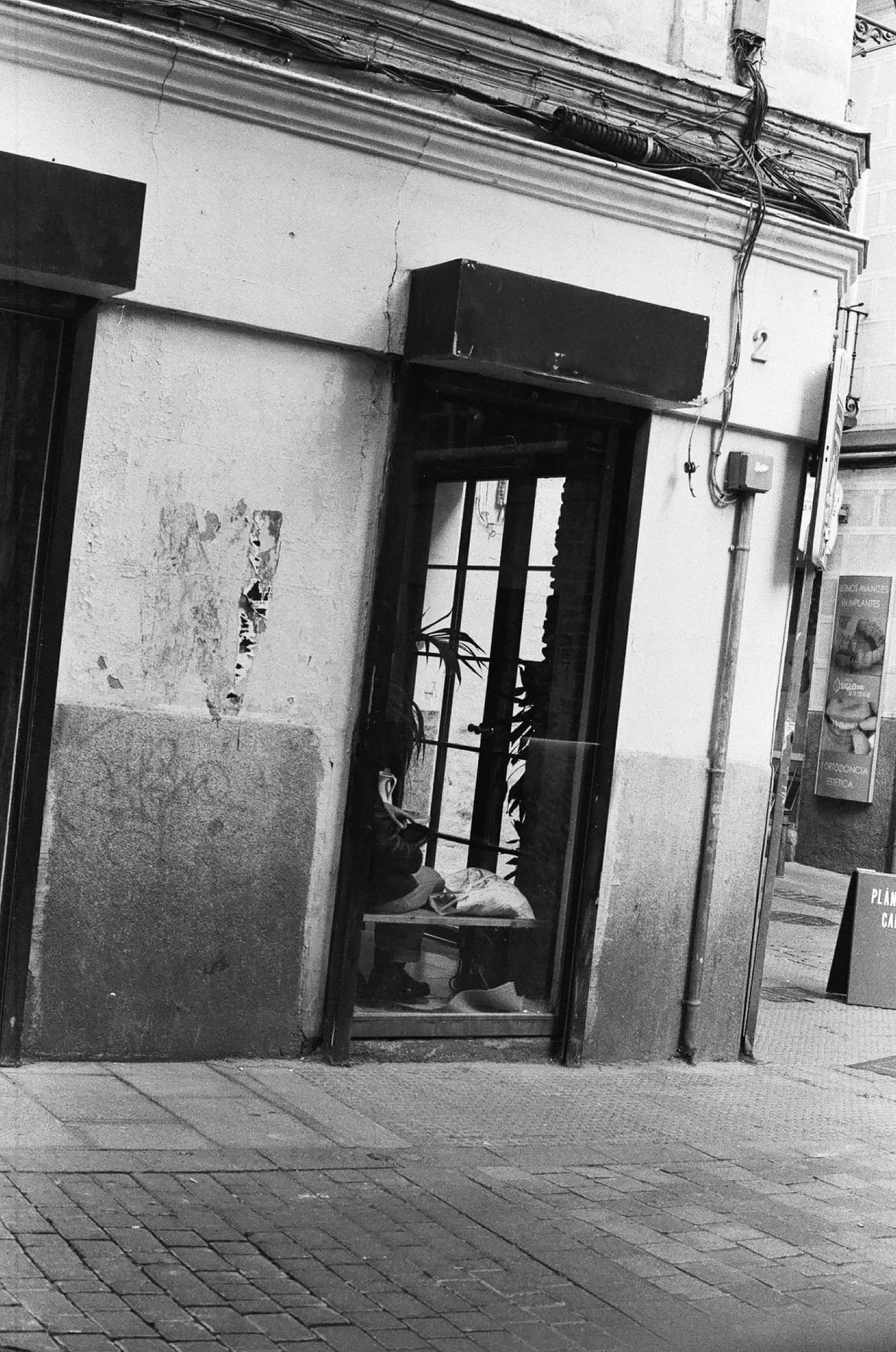 Fachada inclinada con una figura tras la ventana